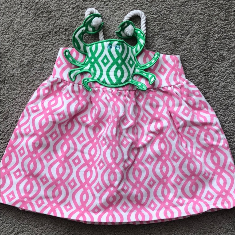 Pink and white sundress with crab appliqué.